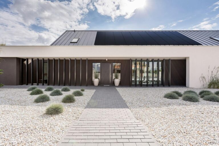 A spacious residence featuring substantial solar panels affixed to its roof