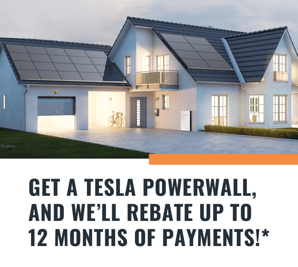 Photo of a home at night lit up, with a Tesla Powerwall and Solar Panels.