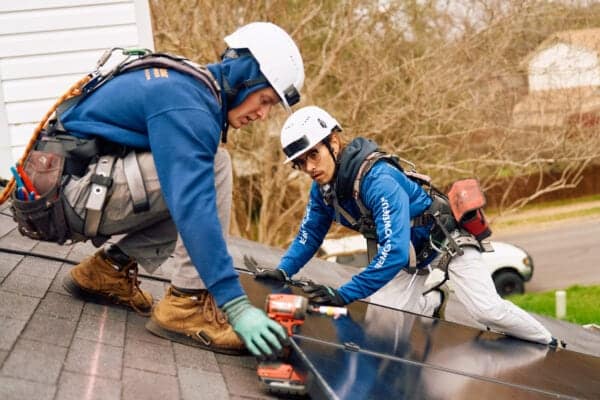 Installers Laying Solar Panels on Roof