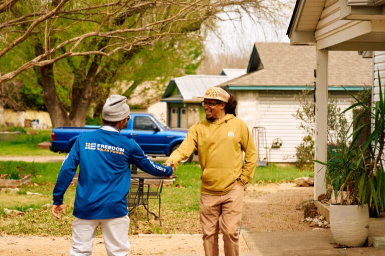 solar installer homeowner shaking hands