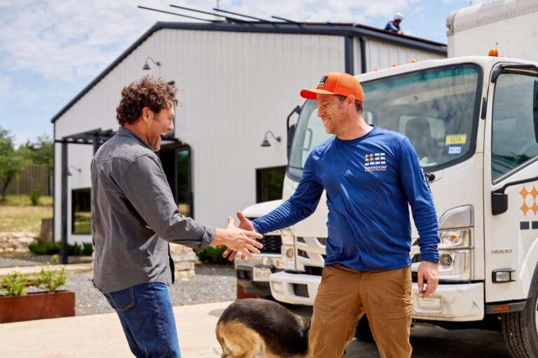 Todd White shakes hands with Nathan, a Freedom Solar Power Install Leader.