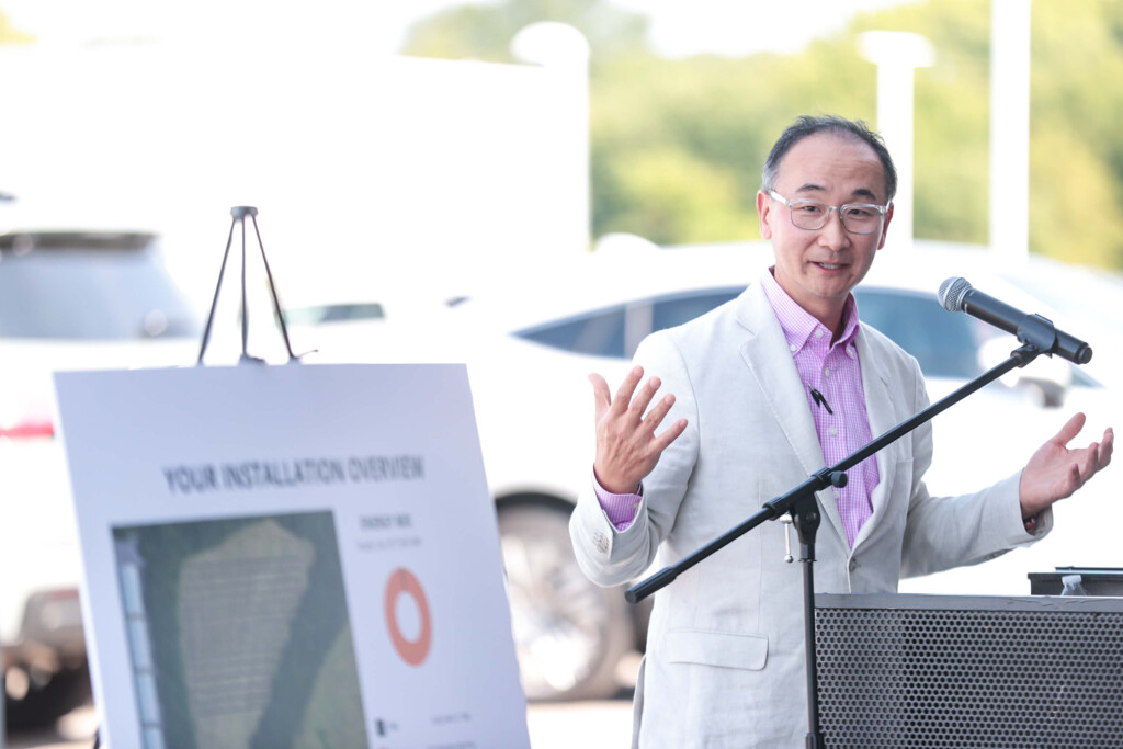 Mark Yamauchi, sustainability strategy manager at Toyota Motor North America, speaks in front of Chuck Hutton Toyota solar farm design built by Freedom Solar Power.
